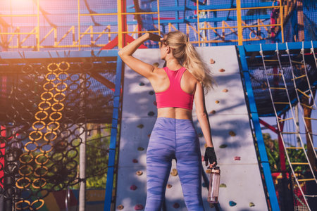 Athletic young woman working out and climbing at the artificial rock in training camp.の写真素材