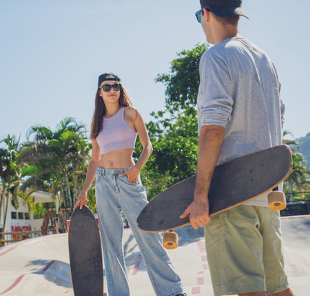Young happy couple with skateboards enjoy longboarding at the skateparkの写真素材