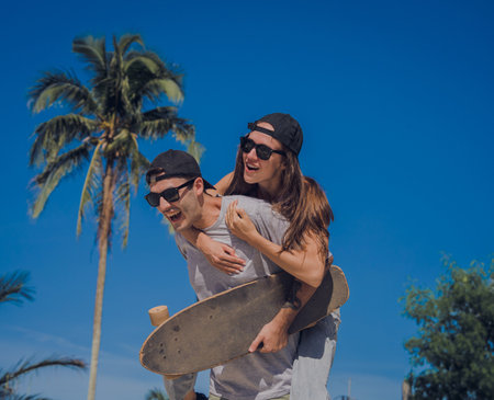 Young happy couple with skateboards enjoy longboarding at the skateparkの写真素材
