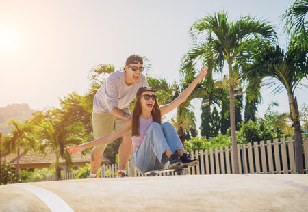 Young happy couple with skateboards enjoy longboarding at the skateparkの写真素材