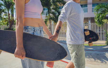 Young happy couple with skateboards enjoy longboarding at the skateparkの写真素材