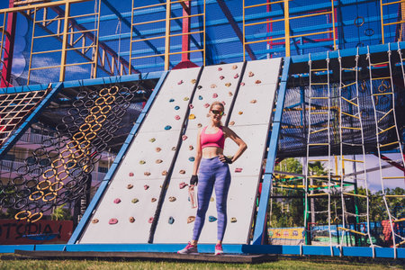 Athletic young woman working out and climbing a ropes at the rope training camp.