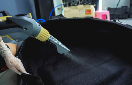 Young woman cleaning the car details with a washing vacuum cleanerの写真素材