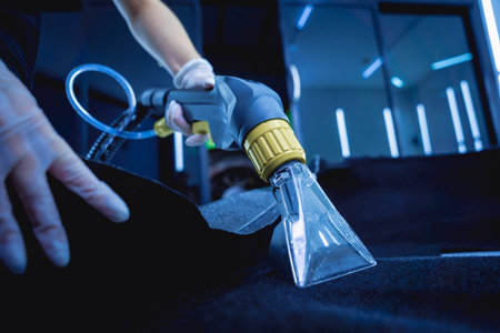 Young woman cleaning the car details with a washing vacuum cleaner