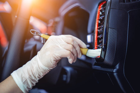 Young woman cleaning the car interior using a special brush with foamの写真素材