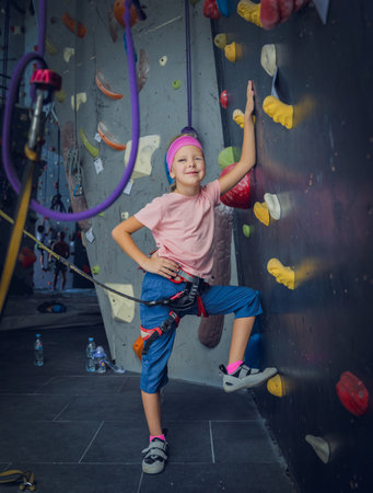 A strong baby climber posing for photographer at artificial wall.の写真素材
