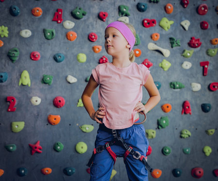 A strong baby climber posing for photographer at artificial wall.の写真素材