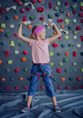 A strong baby climber posing for photographer at artificial wall.の写真素材