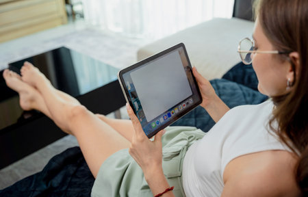 Young woman looking at home security cameras on tablet computerの写真素材