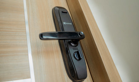 Modern smart door lock on the wooden door in a cozy apartmentの写真素材