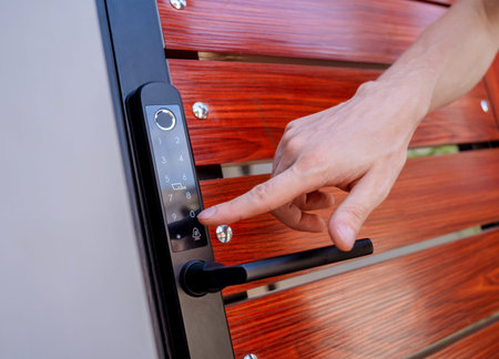 A technician installs a modern smart door lock on the wood door