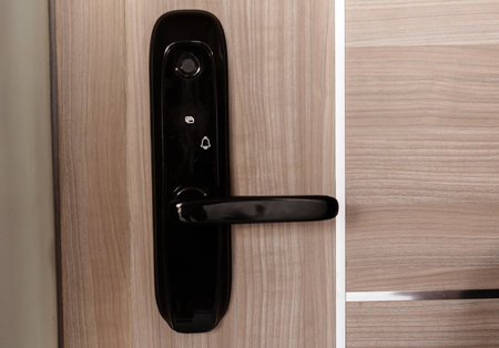 Modern smart door lock on the wooden door in a cozy apartmentの写真素材