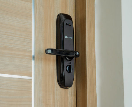 Modern smart door lock on the wooden door in a cozy apartment