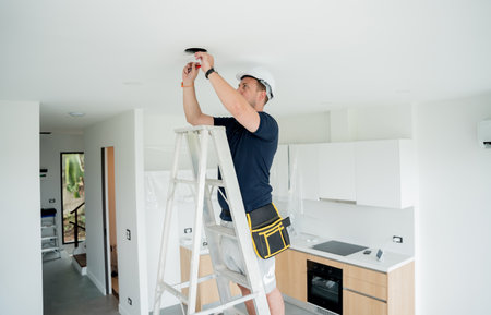 technician is installing an LED spotlight in the ceiling.の写真素材
