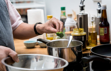Chef at the kitchen preparing lentils soup with cauliflower and broccoli