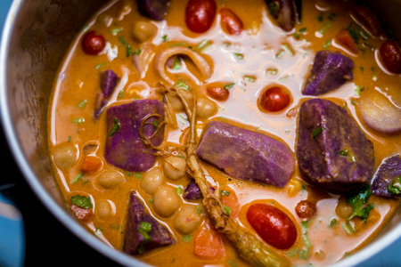 Chef at the kitchen preparing massaman curry with sweet potato and many spicesの写真素材