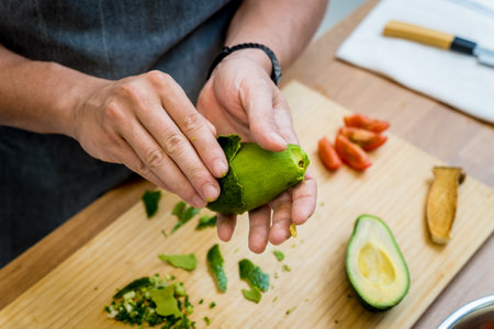 Chef at the kitchen preparing healthy quinoa bowl with avocadoの写真素材