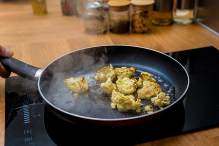 Chef at the kitchen preparing bean porridge with cauliflower and vegetablesの写真素材