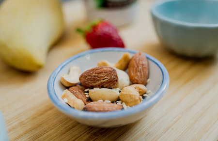 Cutting board with ingredients for preparing bowl of oats with strawberries and mangoの写真素材