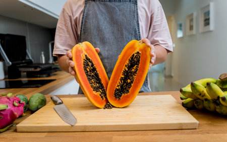 Chef cuts and peels papaya on the cutting boardの写真素材