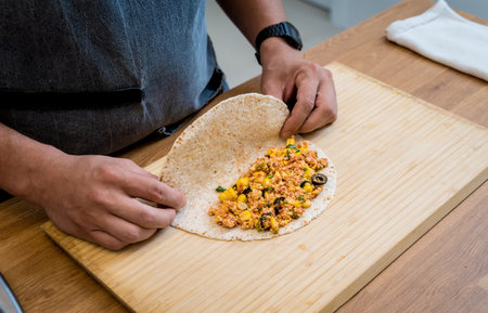 Chef at the kitchen preparing quesadillas with tofu and sweet cornの写真素材
