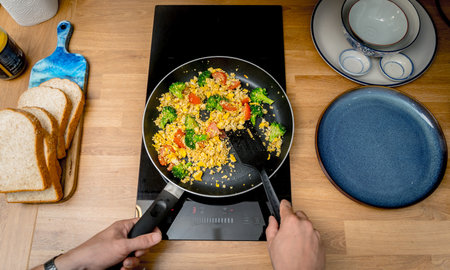 Chef at the kitchen preparing tofu scramble with vegetablesの写真素材