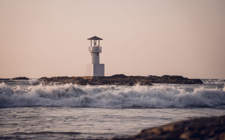 Lighthouse surrounded by water and cloudy sunset skyの写真素材