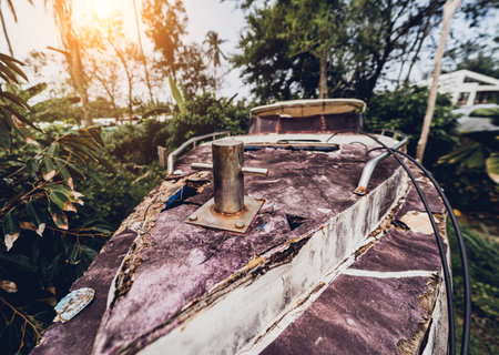 Old and rusty motor boats on a landfill surrounded by tropical forestの写真素材