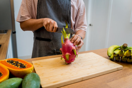 Chef cuts and peels dragon fruit on the cutting boardの写真素材