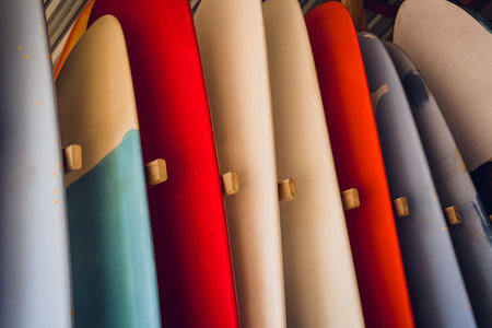 A variety of surfboards are neatly displayed on a standの写真素材