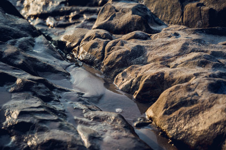 A large rocks surrounded by waves of the oceanの写真素材