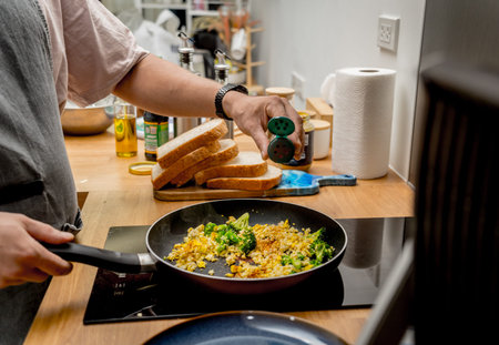 Chef at the kitchen preparing tofu scramble with vegetables