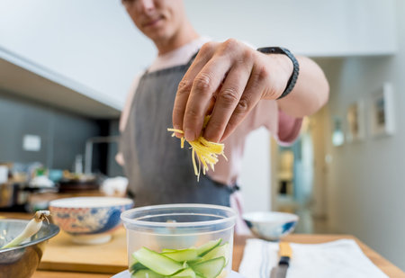 Chef at the kitchen preparing rice porridge with onion and sesame seeds