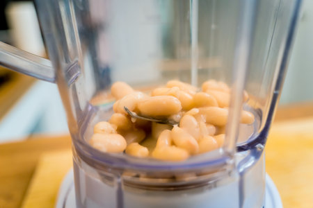 Chef at the kitchen preparing bean porridge with cauliflower and vegetablesの写真素材