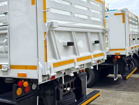 Two trucks are parked beside each other in a parking area