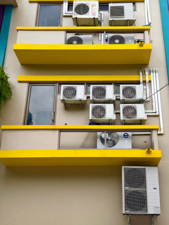 There are numerous air conditioners installed on the exterior of the buildingの写真素材