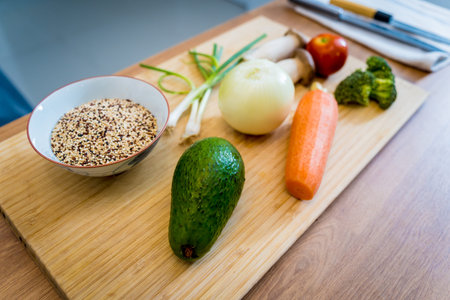 Cutting board with ingredients for preparing healthy quinoa bowl with avocadoの写真素材