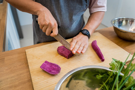 Chef at the kitchen preparing massaman curry with sweet potato and many spicesの写真素材
