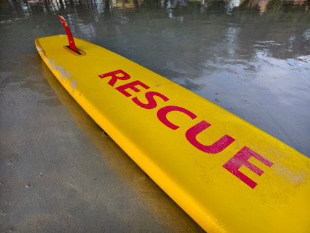 Bright yellow rescue surfboard at the ocean beach