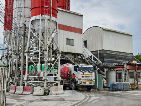 A concrete mixer truck is stationary outside of a concrete factoryの写真素材