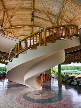 There is a spiral staircase in a building with a wooden railingの写真素材