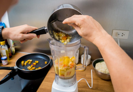 Chef at the kitchen preparing pumpkin porridge with tofu and vegetables