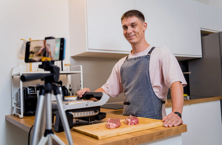The chef is broadcasting live from workshop how to prepare a beef steaks on the electric grillの写真素材