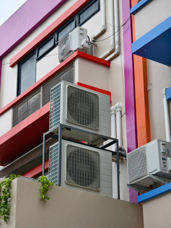 There are numerous air conditioners installed on the exterior of the building