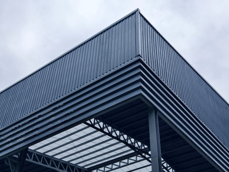 A large building with metal roof against a cloudy sky