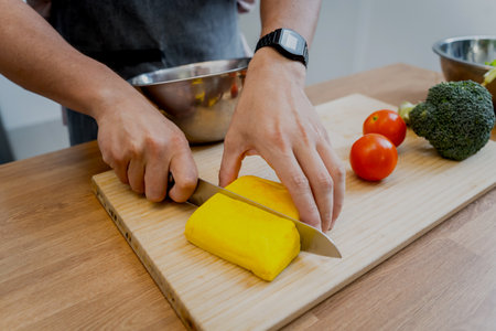Chef at the kitchen preparing tofu scramble with vegetablesの写真素材