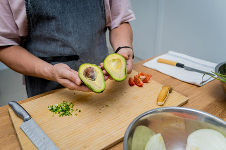 Chef at the kitchen preparing healthy quinoa bowl with avocado