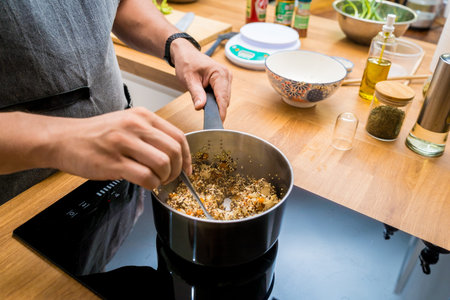 Chef at the kitchen preparing healthy quinoa bowl with avocadoの写真素材