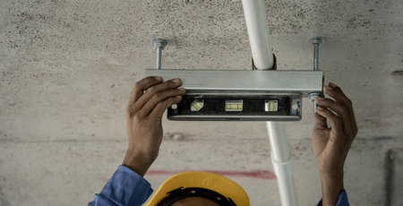 A man in a hard hat is working with level toolの写真素材