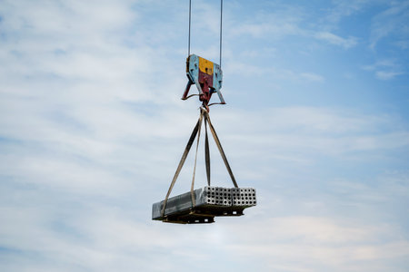 Heavy construction load being lifted by a tall craneの写真素材